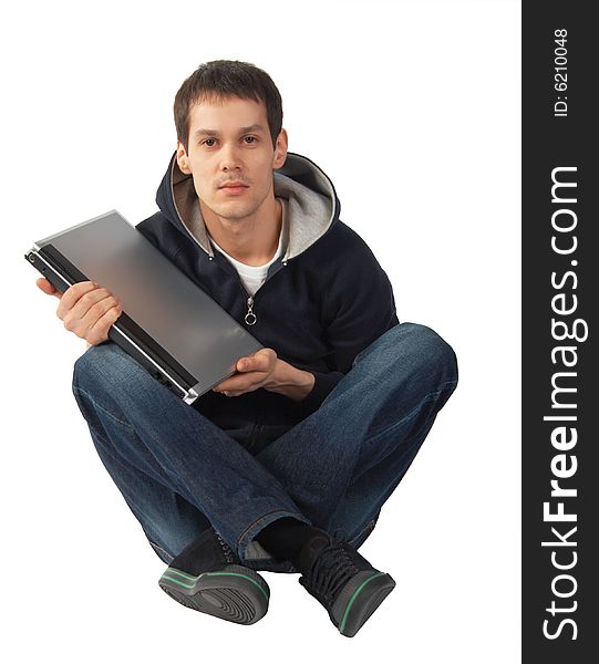 Young man with laptop sits on floor isolated