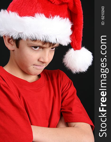 Young boy wearing a red shirt and christmas hat. Young boy wearing a red shirt and christmas hat