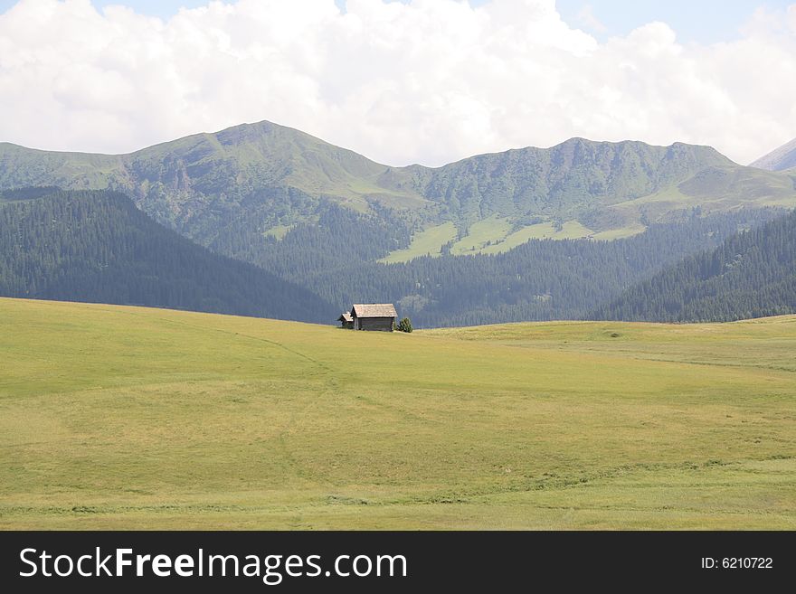 Lonely cottage in front of a mountain range