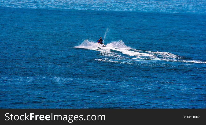 The racer on the scooter in the high sea