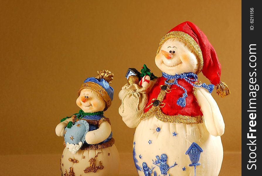 Two snowmen against brown background