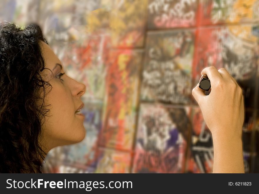 Woman painting something on a brick wall. Woman painting something on a brick wall