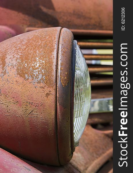 Rust and peeling paint on an old truck headlight.