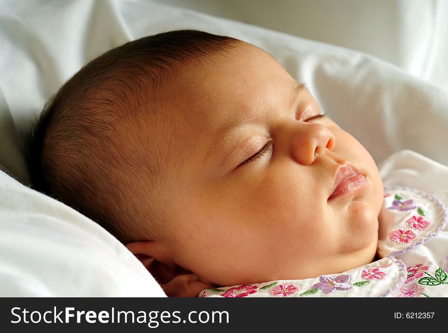 A little cute baby portrait over white sleeping. A little cute baby portrait over white sleeping