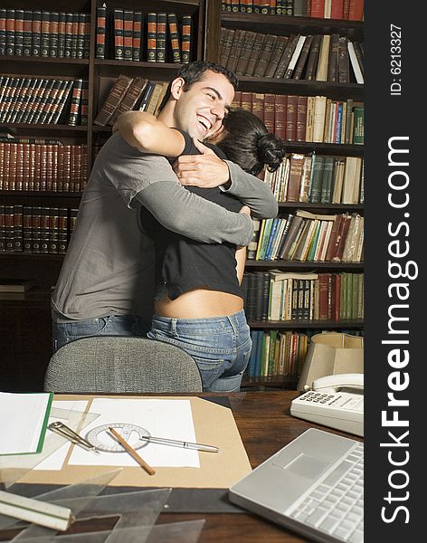 Couple in an office hugging. Couple in an office hugging