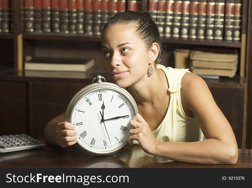 Woman smiling as she holds a clock - Horizontally framed photo. Woman smiling as she holds a clock - Horizontally framed photo.