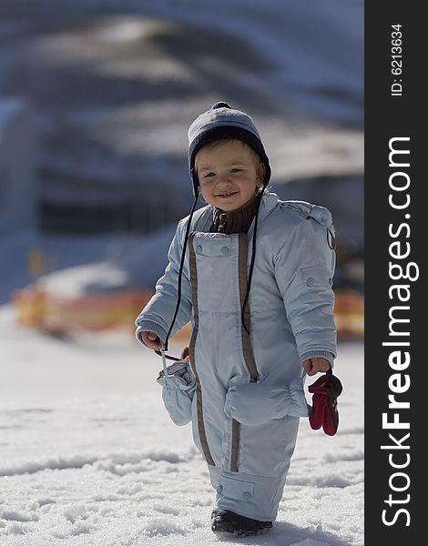 Small child in the overalls in winter