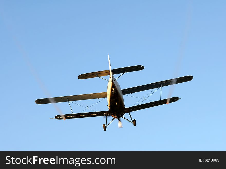 Airplane spraying, isolated over blue sky. Airplane spraying, isolated over blue sky