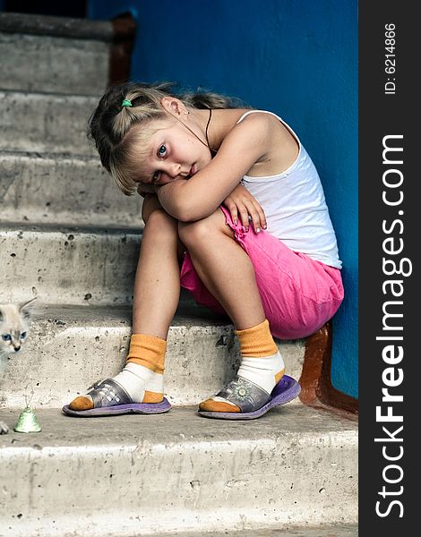 Little girl is sitting on concrete stairs. Little girl is sitting on concrete stairs