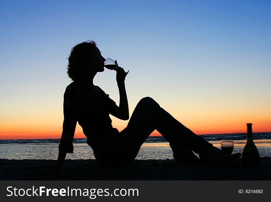 Young girl drinking wine on the beach. Young girl drinking wine on the beach