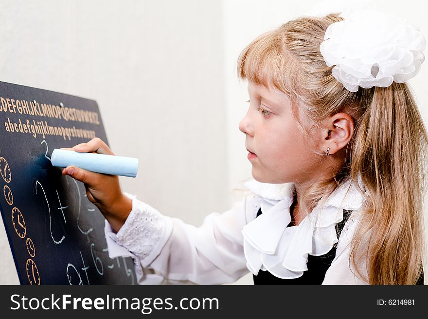 An image of Little girl writing on blackboard. An image of Little girl writing on blackboard.