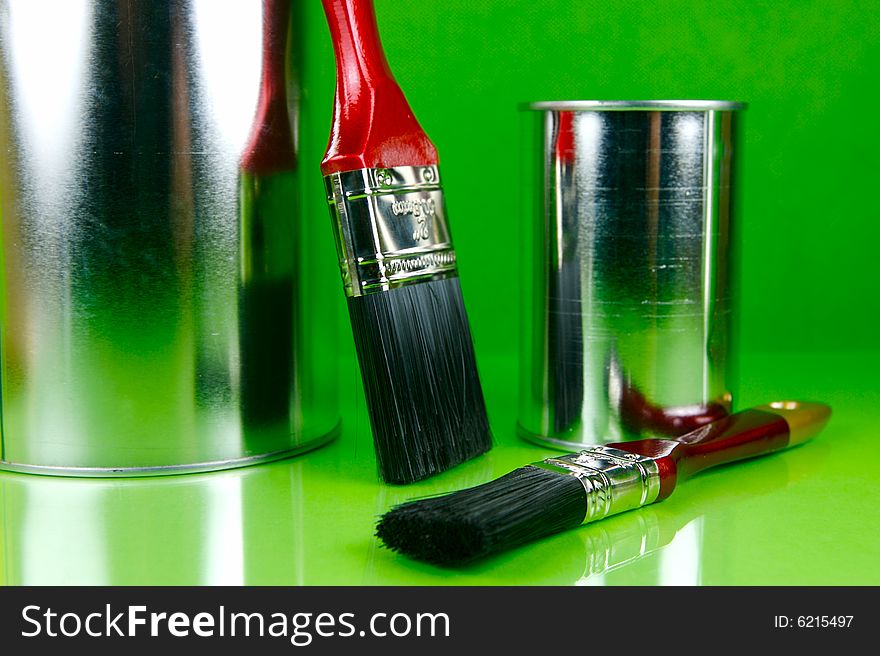 Paints and brushes isolated against a green background. Paints and brushes isolated against a green background