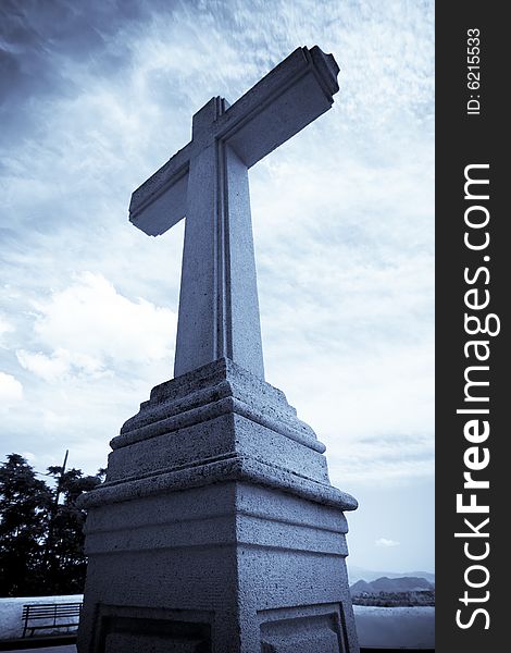 Christian stone cross under blue sky
