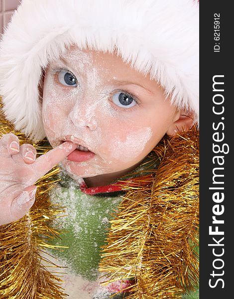 Toddler wearing a christmas hat, baking christmas cookies