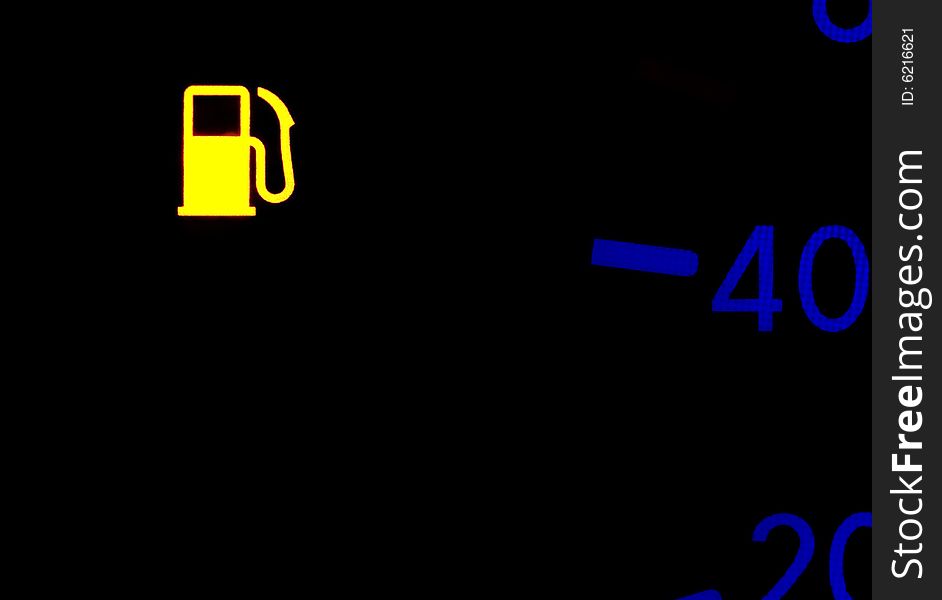 Yellow backlited fuel check light over black background