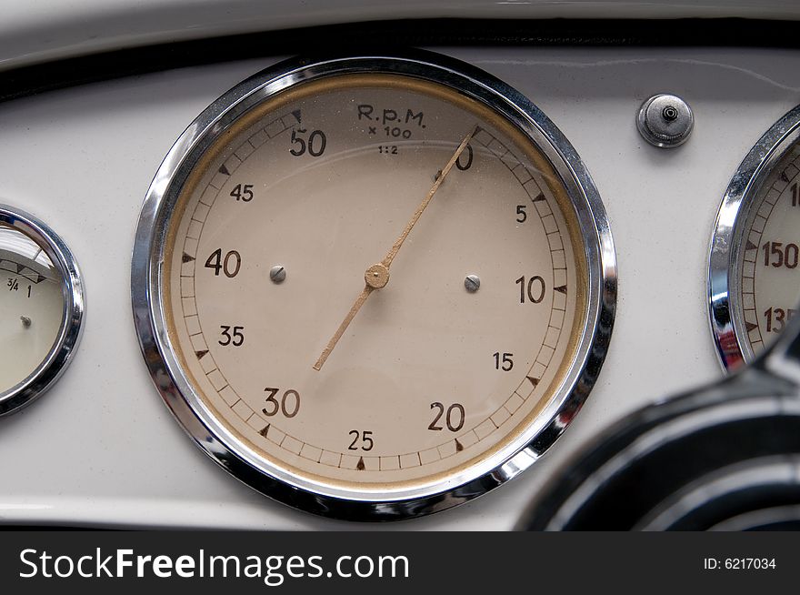 Tachometer, speedometer and fuel gauge in an old sheet steel dashboard.