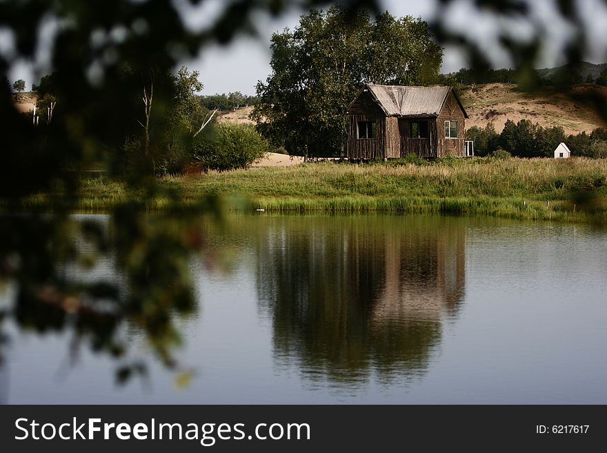 A mountain lake with a summer house on the shore.