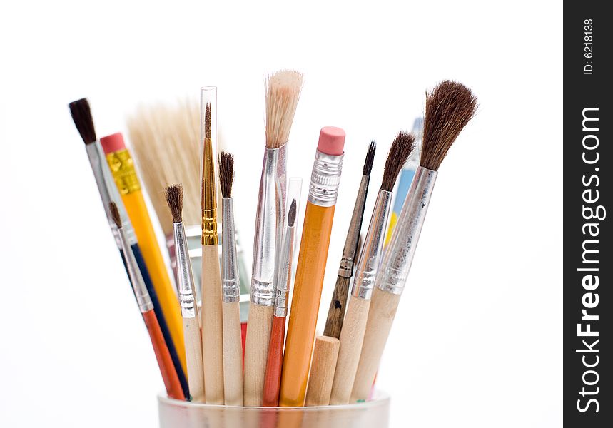 Pencils and brushes closeup at white background