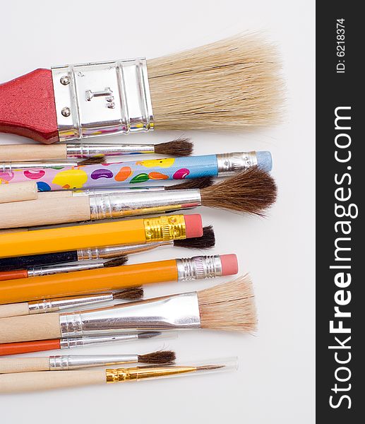 Pencils and brushes closeup at white background