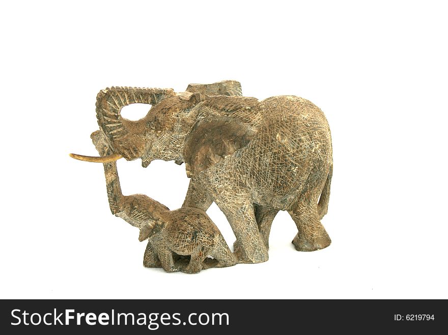 A hand carved mother elephant and her calf isolated on a white background. A hand carved mother elephant and her calf isolated on a white background