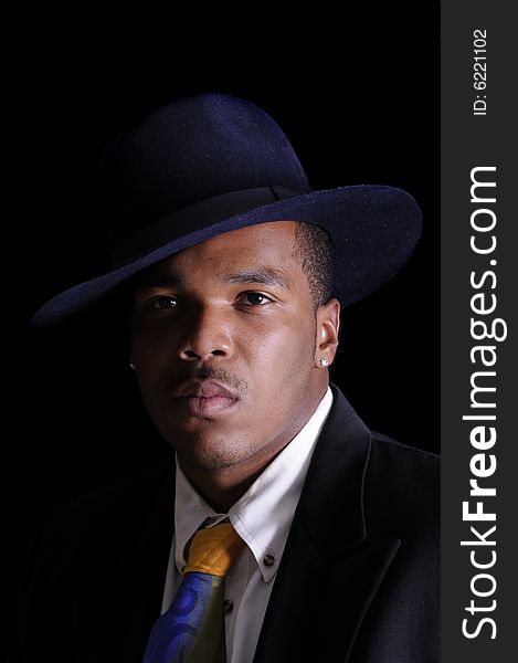 Young African American man in a hat and suit