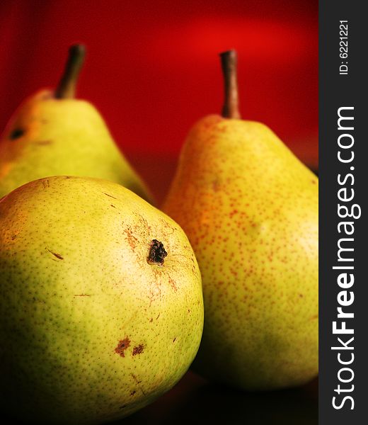 Three pears on red background