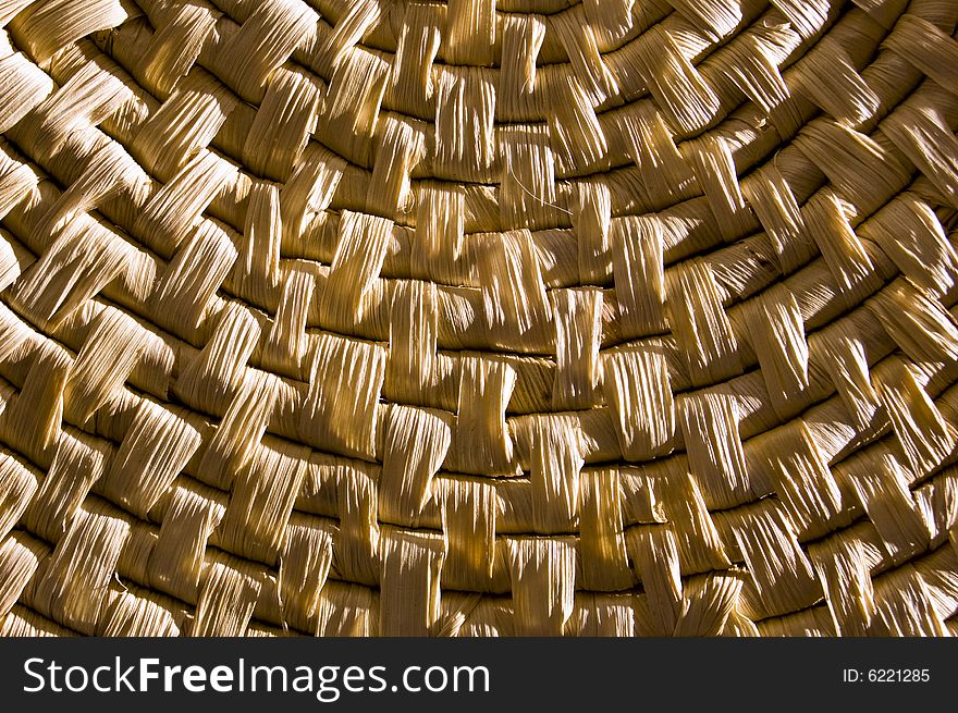Detail of a container made of straw, with hard contrast, enlightened from right by flash light source. Detail of a container made of straw, with hard contrast, enlightened from right by flash light source