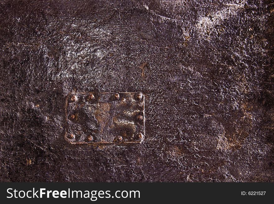 Detail of an old furniture covered by black leather. Detail of an old furniture covered by black leather