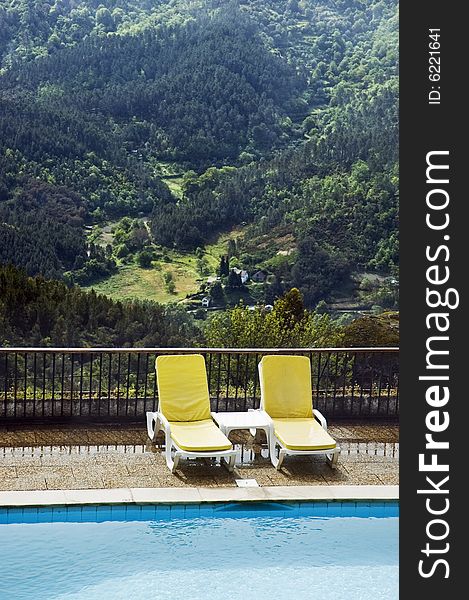 Long chairs by the pool in a mountain landscape. Long chairs by the pool in a mountain landscape