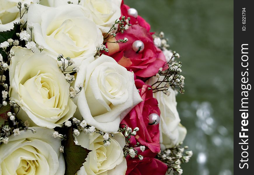 Close-up of wedding bouquet with beige and red roses