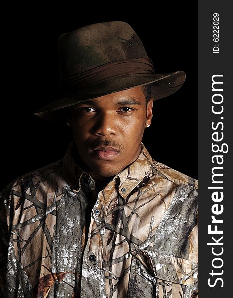 Young African American man in a hat and camouflage shirt