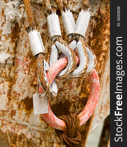 A ring connector, attached to a steel cable, connected to four other steel cables through their eyelets. A ring connector, attached to a steel cable, connected to four other steel cables through their eyelets