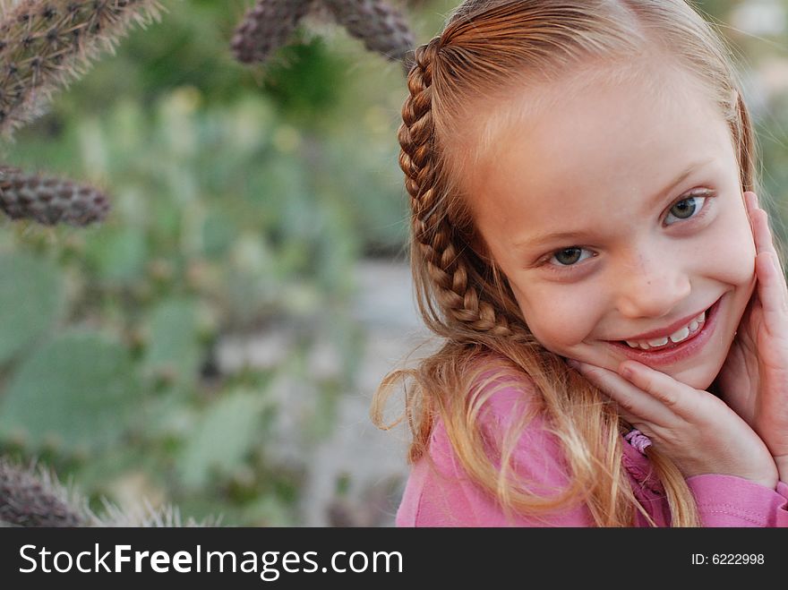 Young girl with braid smiling with her hands to her cheeks. Young girl with braid smiling with her hands to her cheeks