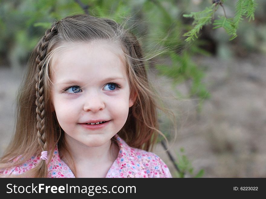 Young girl looking up and to the side with her hair blowing in the wind