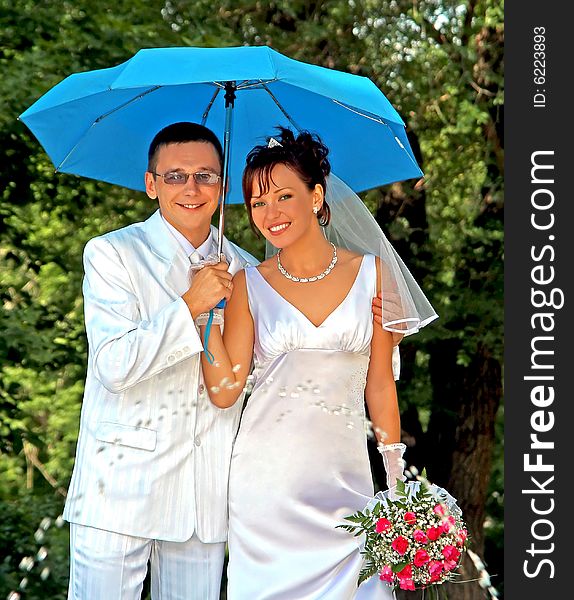 Bridegroom and bride with the umbrella