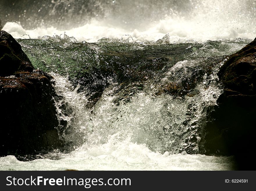 The bottom of a waterfall with flowing water. The bottom of a waterfall with flowing water