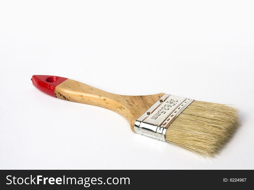 A small wooden paint brush isolated against a plain background