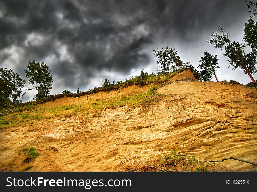 Sandy cliff on stormy clouds. Sandy cliff on stormy clouds.