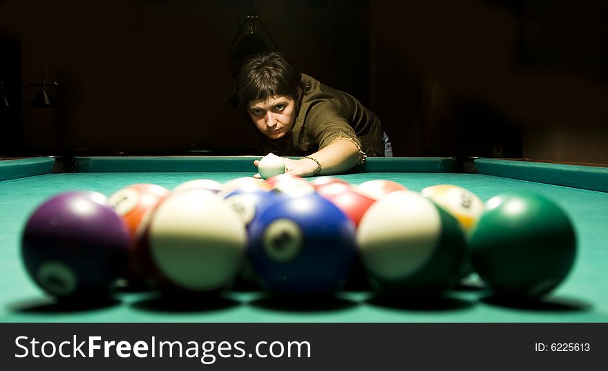 Young caucasian woman playing billiard