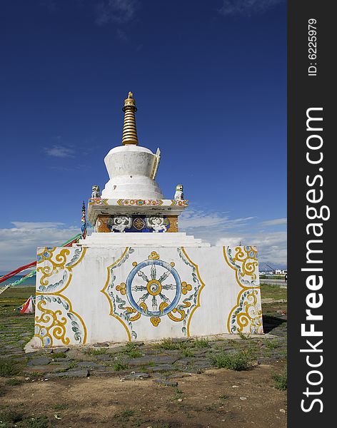 White Pagoda on Base with Tibetan Decoration against Blue Sky