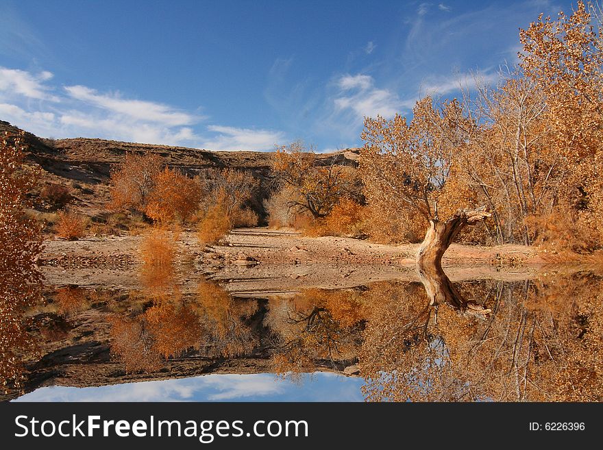 View of the red rock formations in San Rafael Swell with blue skyï¿½s and water reflections. View of the red rock formations in San Rafael Swell with blue skyï¿½s and water reflections
