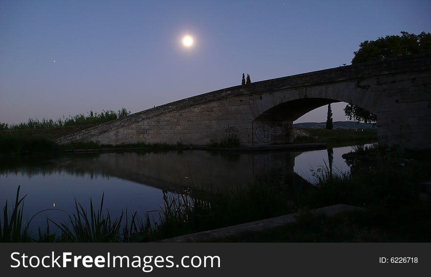A bridge standing on the canal-du-midi in the moolight. A bridge standing on the canal-du-midi in the moolight