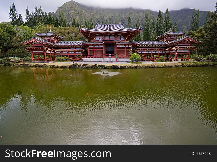 Byodo-In temple tucked away in valley of temples, oahu, hawaii, at foothills of koolau mountains by a calm pond. Byodo-In temple tucked away in valley of temples, oahu, hawaii, at foothills of koolau mountains by a calm pond