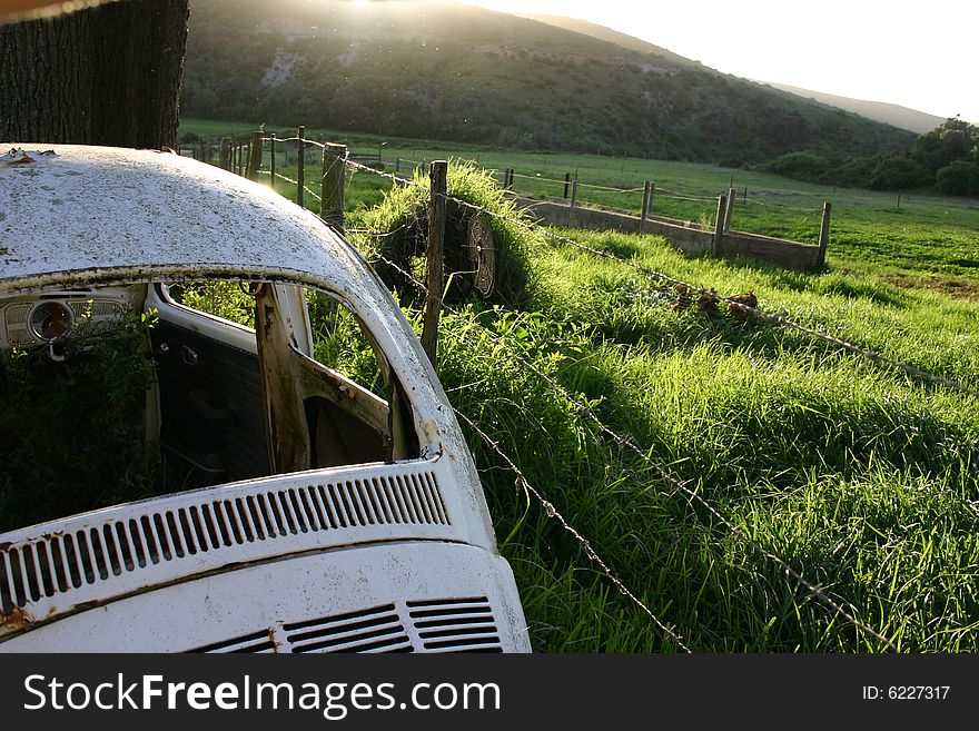 Old rusty car next to fence