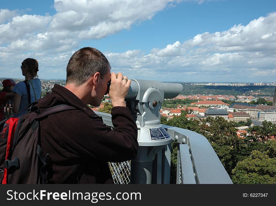 Man on the balcony is looking through binocular. Man on the balcony is looking through binocular