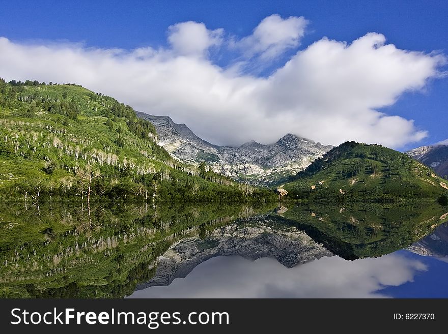 Mountain Lake showing 
 reflectionswith blue sky and clouds. Mountain Lake showing 
 reflectionswith blue sky and clouds