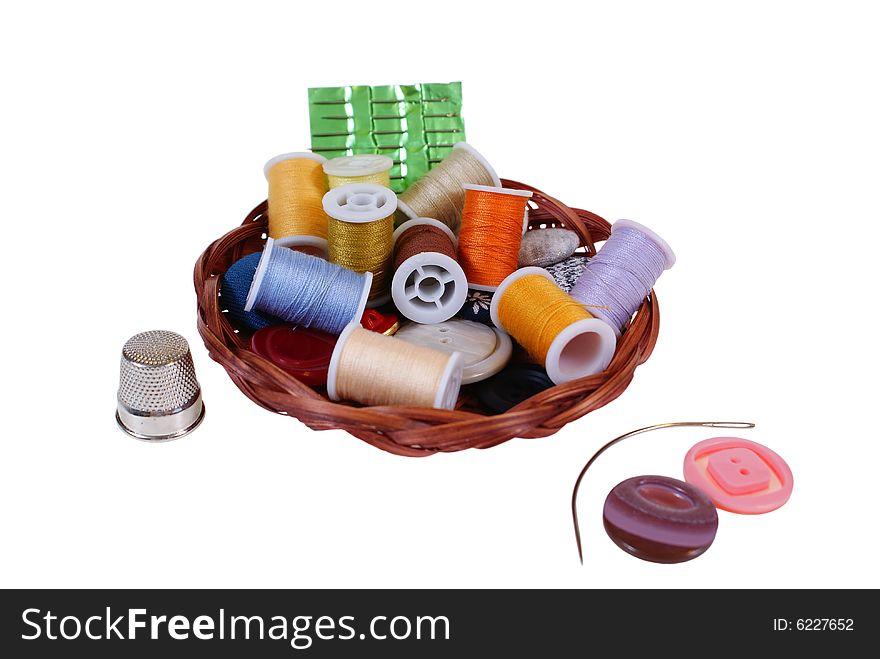 Threads and buttons in work basket isolated on white background