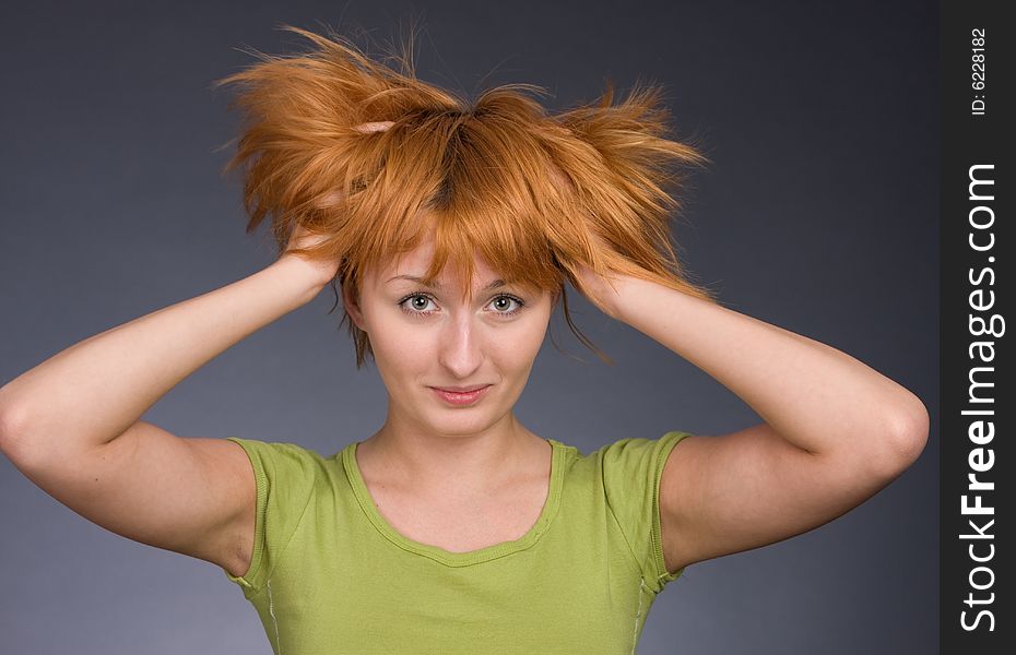 Portrait of the red-haired girl in a green T-shirt against a dark background