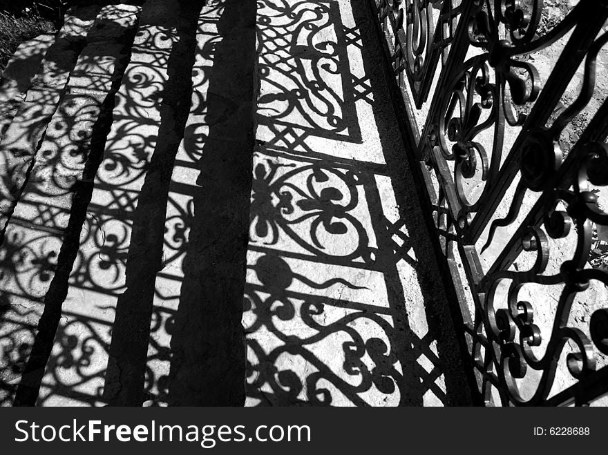 Patterned shade on steps from the forged gate