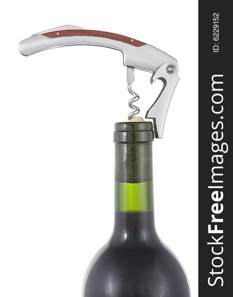 Opening wine bottle with a corkscrew on white background